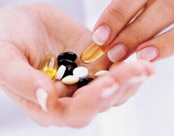 Hand holding supplements/pills.