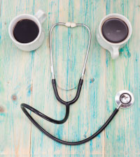 Two coffee mugs and stethoscope in shape of smiley face