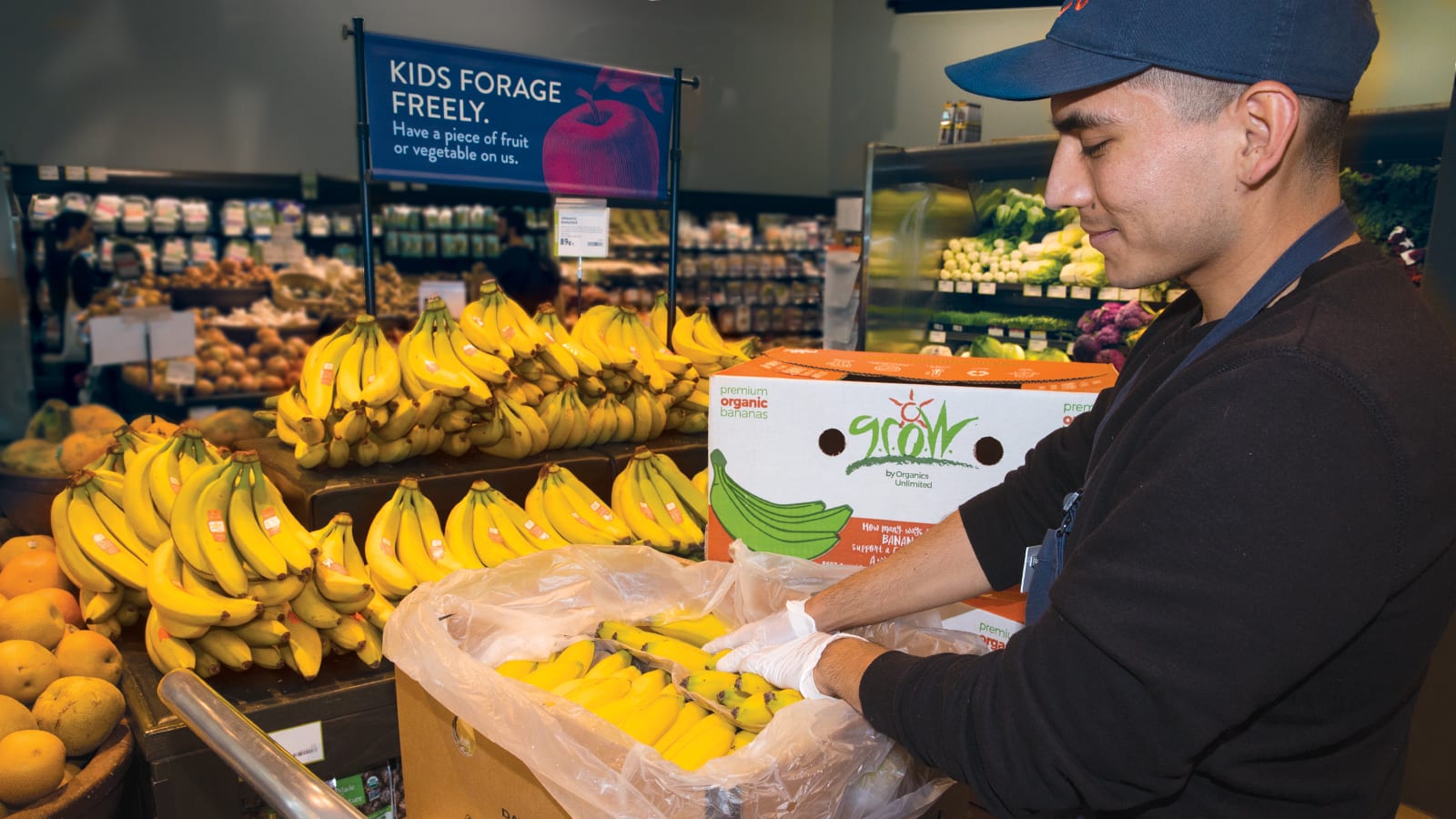 Produce clerk Bryant Vidrio stocks GROW bananas at Fremont PCC.