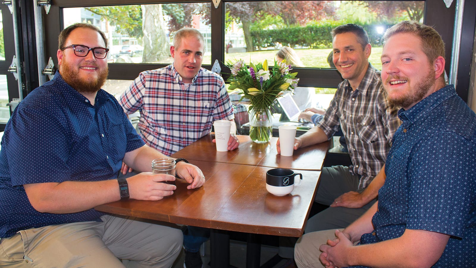 Drew Hunter and Josh Fox, PCC View Ridge store director and assistant store director, learn about coffee training operations with Street Beans Sean McDonald and Daniel Elliff.