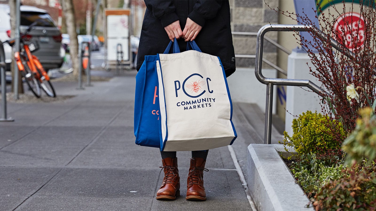 PCC member holding PCC branded totes outside of Fremont PCC.