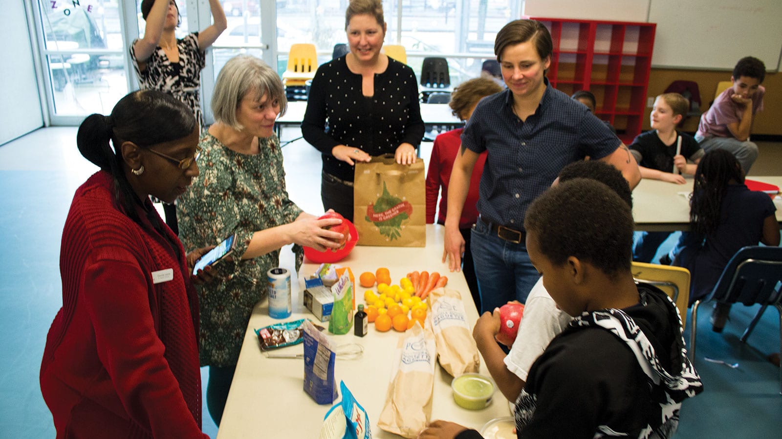 PCC Columbia City and Smilow Rainier Vista Boys & Girls club staff and kids of the cooking program discussed preferred ways of getting pomegranate arils loose.