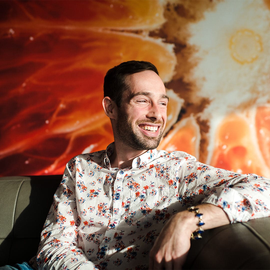 Steven on office couch in front of citrus mural