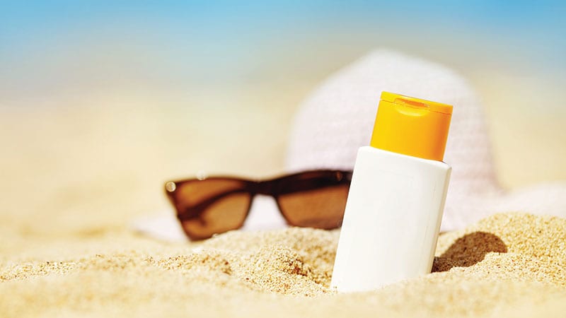 Sunblock and sunglasses on a beach