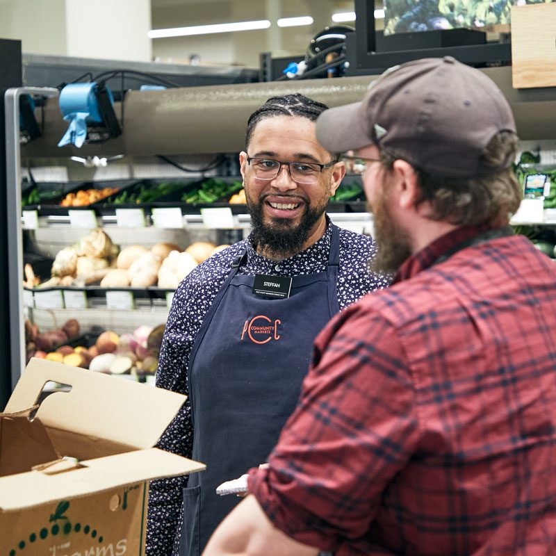 Steffan talking with staff in produce department