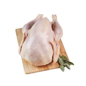 A raw whole turkey on a cutting board with sage leaves.