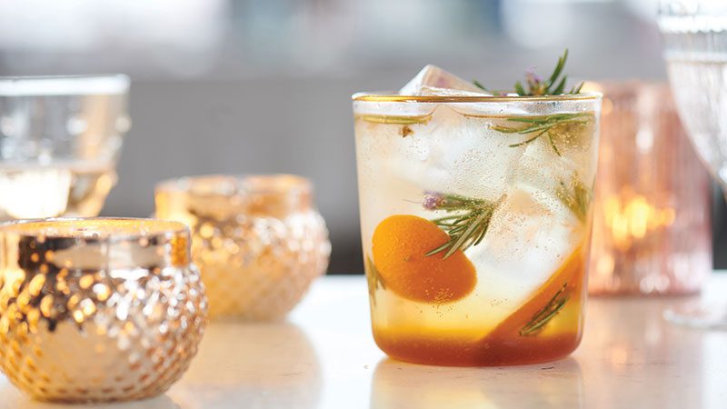 A PCC nonalcoholic drink on a table with candles