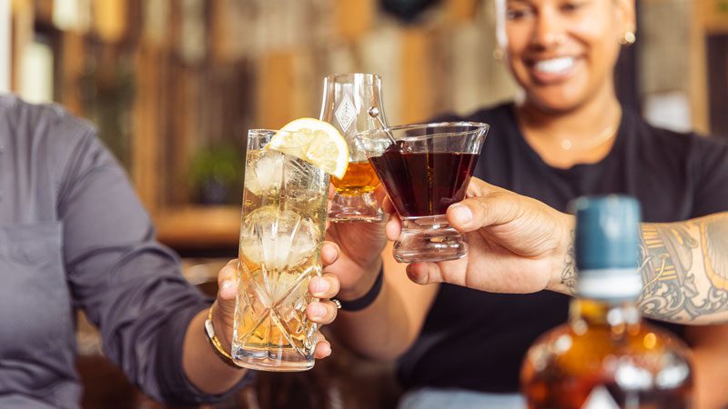 people with drink glasses at a happy hour