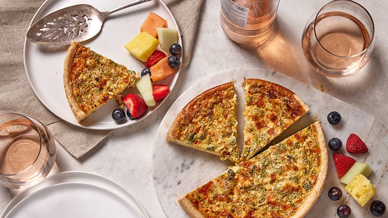 A PCC quiche sliced and served with fruit.