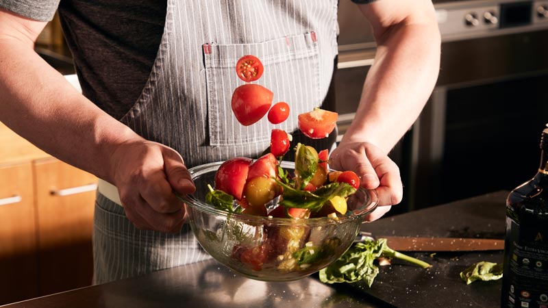 Chopped vegetables being tossed in oil.