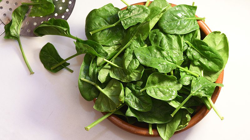Raw spinach in a colander